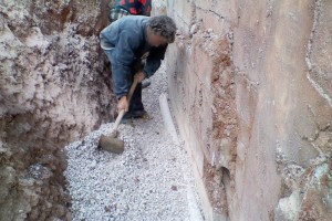 Installing a land drain behind the boundary wall.